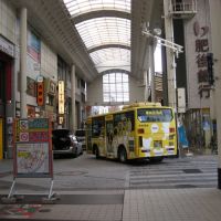 アーケード付き商店街に路線バスが乗り入れる風景, Кумамото