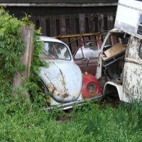 Old Volkswagens rusting away behind a neighbourhood garage., Вернон
