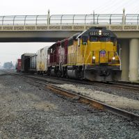 A couple of locomotives haul a short line of freight down the Union Pacific Railroad tracks underneath the P St overpass, 12/2012, Модесто