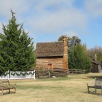 Log cabin at Farmers Branch Historical Park seen from the open field, Фармерс-Бранч