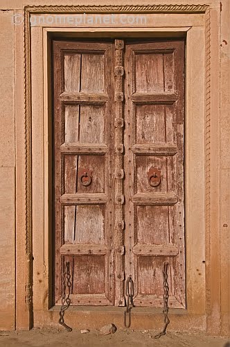 Ancient brown wooden door with blacksmith-made iron chains., Бхаратпур