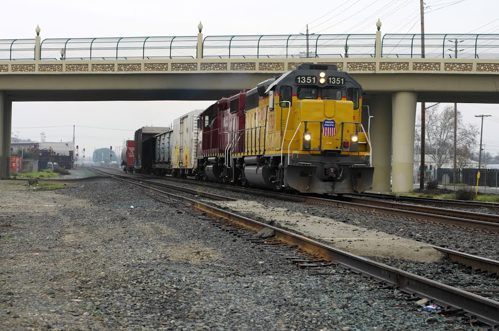 A couple of locomotives haul a short line of freight down the Union Pacific Railroad tracks underneath the P St overpass, 12/2012, Модесто