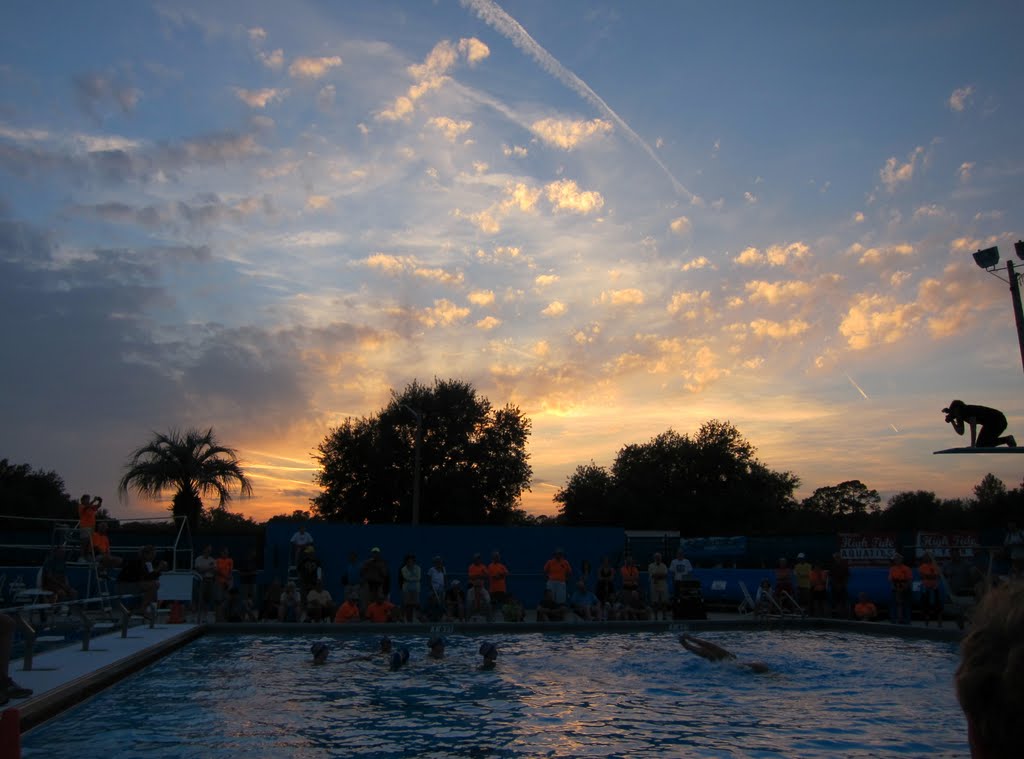 Sunset over synchronized swimmers, and photographer balanced on diving board, Гайнесвилл
